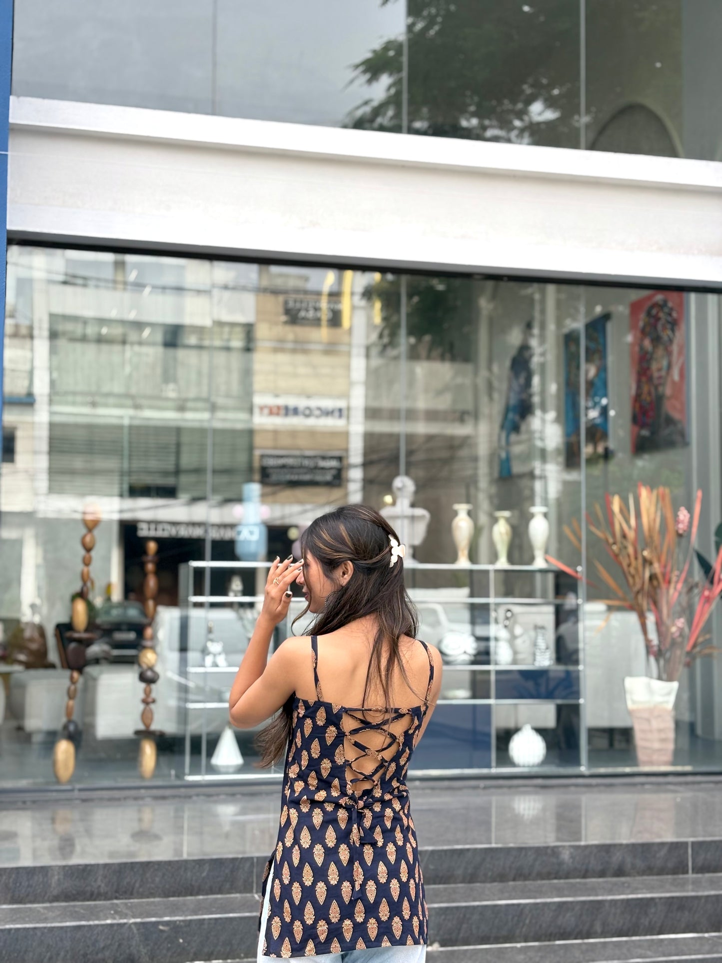 Girl wearing black paisley print halter top with tie-neck detail