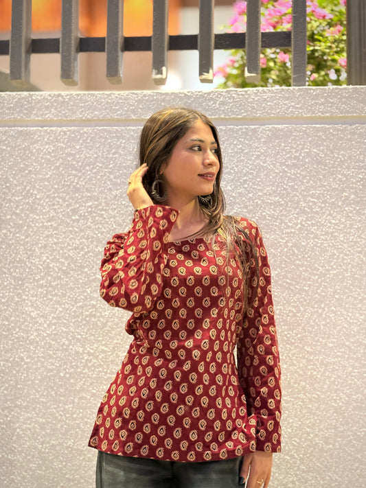 Girl wearing maroon paisley print fitted top with tie-waist detail