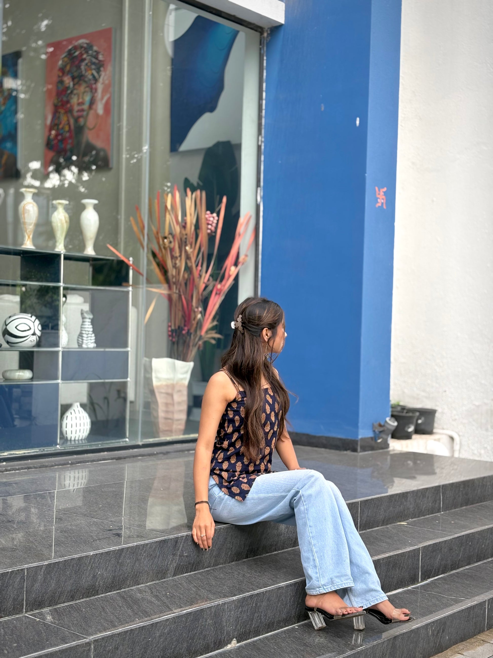Girl wearing black paisley print halter top with tie-neck detail